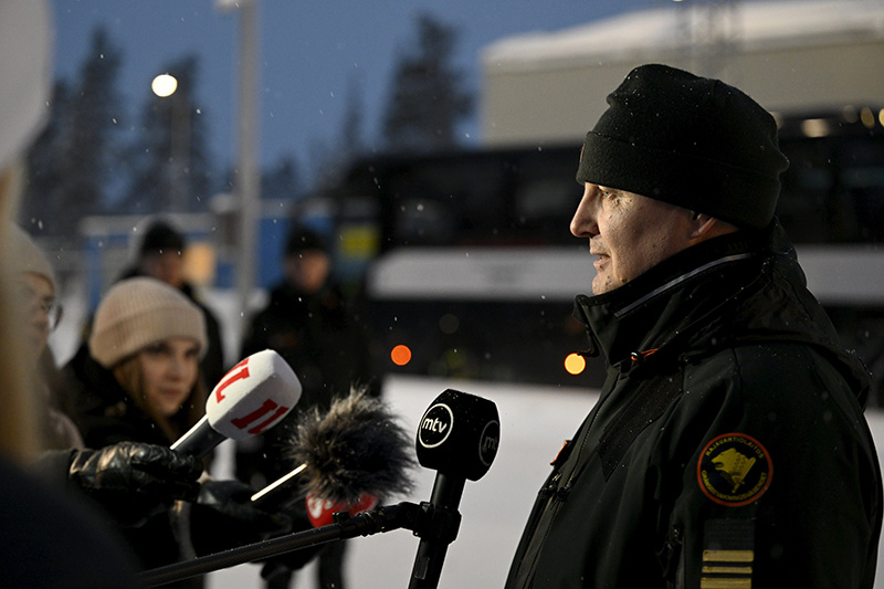 Raja-Joosepin raja-aseman päällikkö Kimmo Louhelainen antaa haastattelua toimittajajoukon mikkien keskellä.