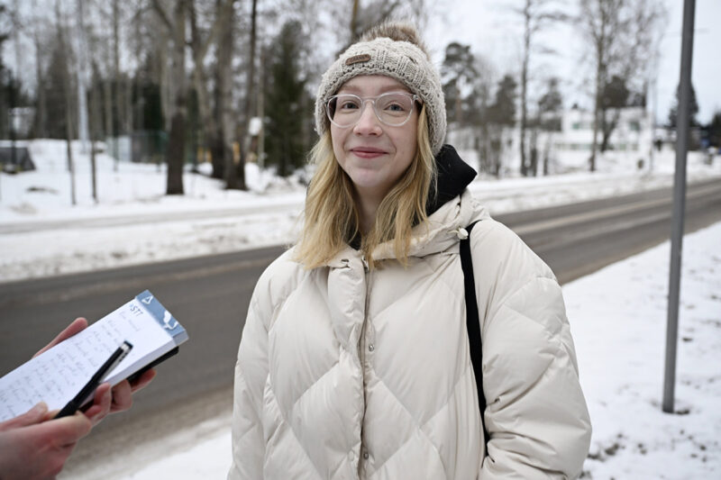 Toimittaja haastattelee naista ulkona kadulla.